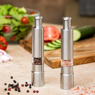 Premium stainless steel salt and pepper grinders for efficient spice dispensing in a kitchen setting.